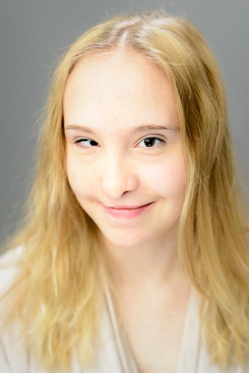 Muotokuva 15-vuotiaasta tytöstä. Hänellä on vaaleat pitkät auki olevat hiukset ja ruskeat silmät.